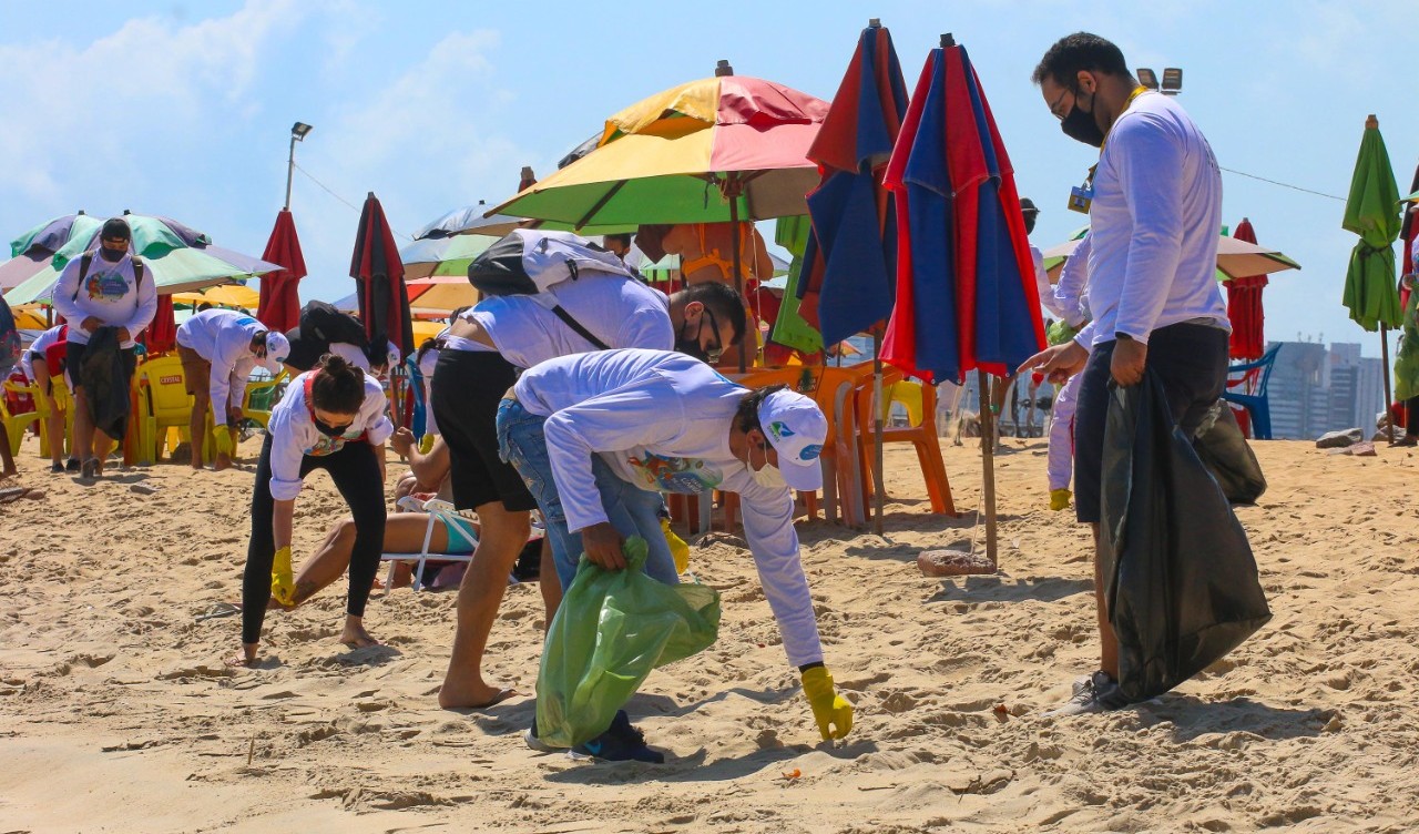 pessoas limpando a praia